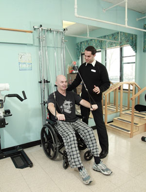 a man exercises under the supervision of a physiotherapist